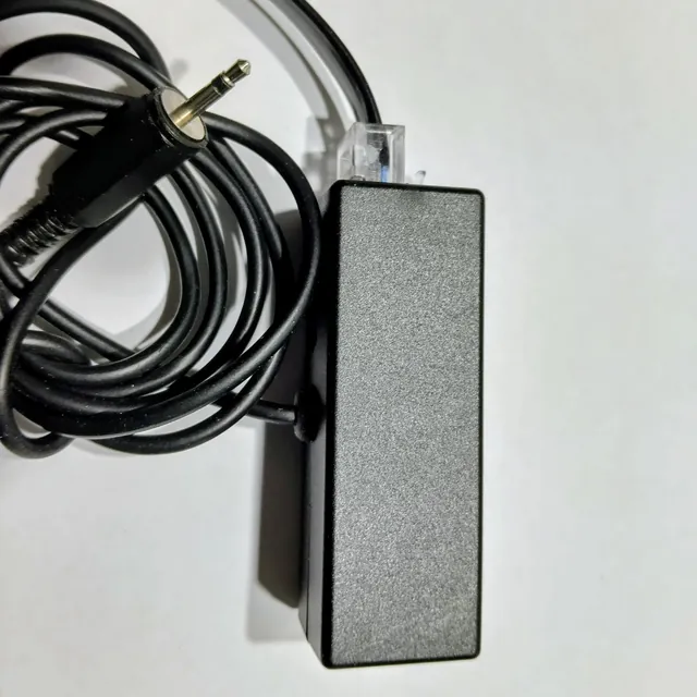 A black adapter box with a 2.5 mm audio plug and a phone connector cable